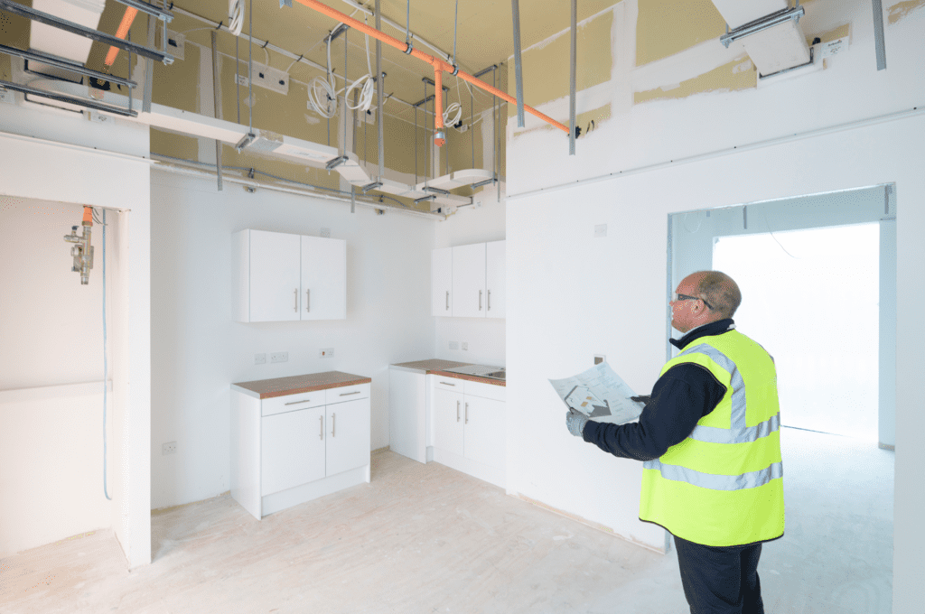 A premier modular worker wearing a high vis vest, surverying an area. 