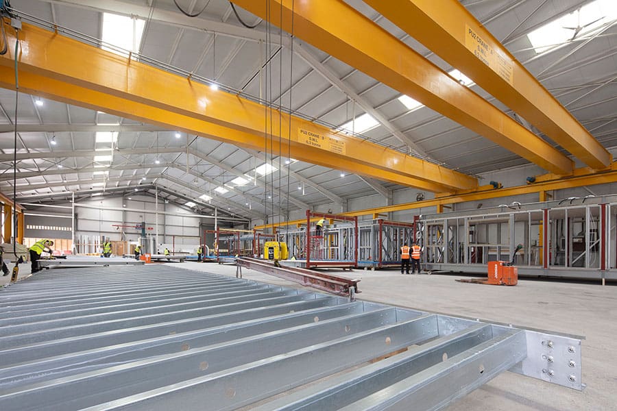 Inside Premier Modulars factory. Construction of a modular building is taking place, with construction workers on site.